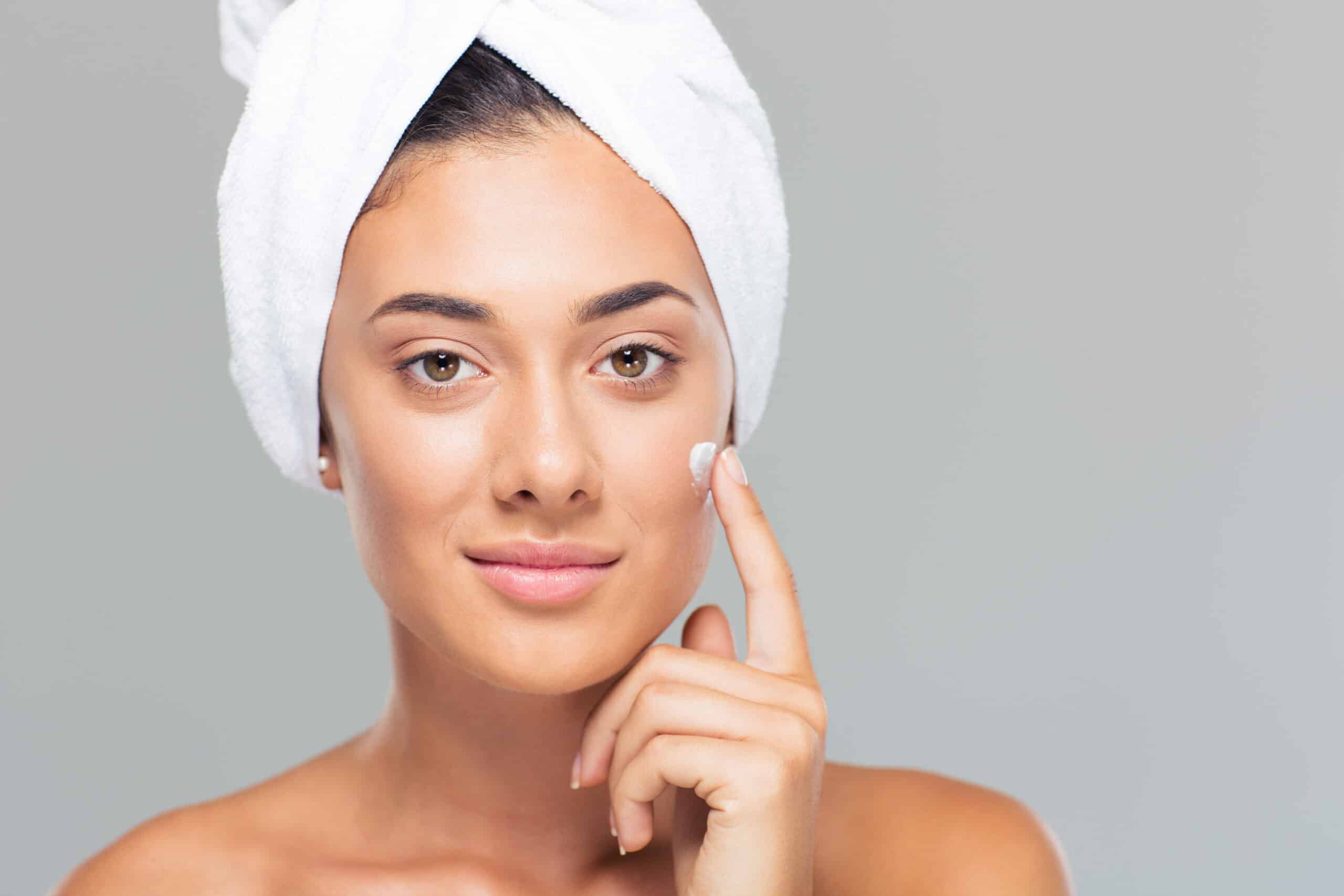 woman with towel on head applying cream on face SBI 300967971 scaled